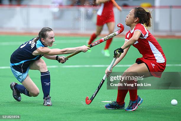 Olga Khonina of Kazakhstan takes a shot against Nicole Kwek of Singapore during round 1 of the 2016 Hockey World League at Sengkang Hockey Stadium on...