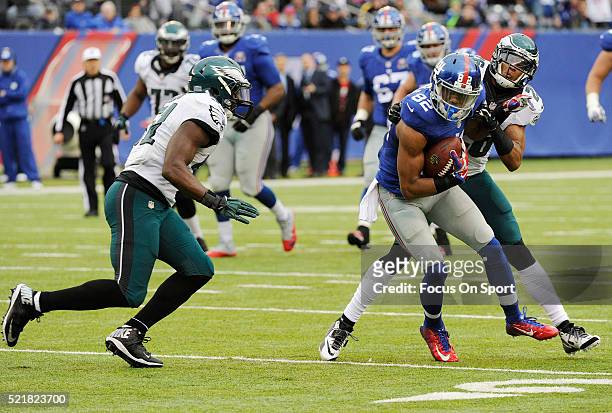Rueben Randle of the New York Giants gets tackled by Emmanuel Acho and Cary Williams of the Philadelphia Eagles during an NFL football game at...