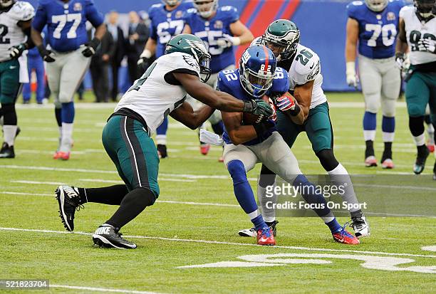 Rueben Randle of the New York Giants gets tackled by Emmanuel Acho and Cary Williams of the Philadelphia Eagles during an NFL football game at...