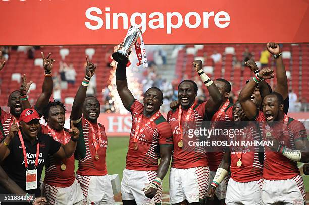 Kenya's team celebrate with the trophy after defeating Fiji in the cup final at the Singapore Sevens rugby tournament on April 17, 2016. / AFP /...