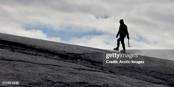 walking on ash covered glacier, svinafellsjokull glacier, iceland - crampon stockfoto's en -beelden