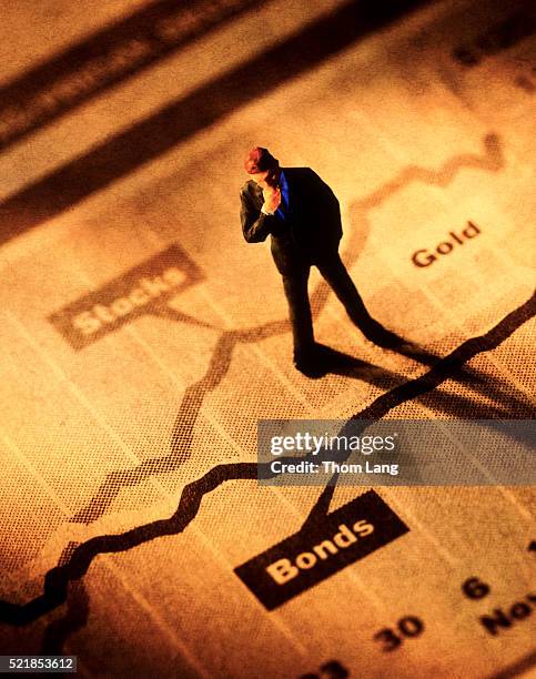 broker standing on stock graphs - bonds foto e immagini stock