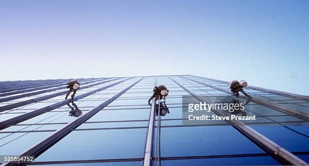 window washers on a skyscraper - window cleaning stock pictures, royalty-free photos & images