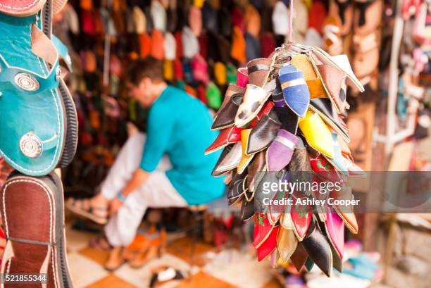 traditional moroccan slippers on a stand at a souk in marrakech, morocco, north africa. - souk stock-fotos und bilder