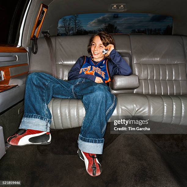 boy in the back seat of limousine using cell phone - showing off stock-fotos und bilder