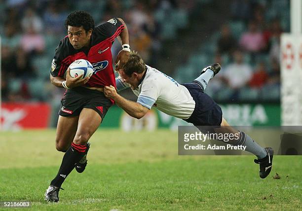 Casey Laulala of the Crusaders is tackled by Shaun Berne of the Waratahs in action during the Super 12 trial match between the NSW Waratahs and the...
