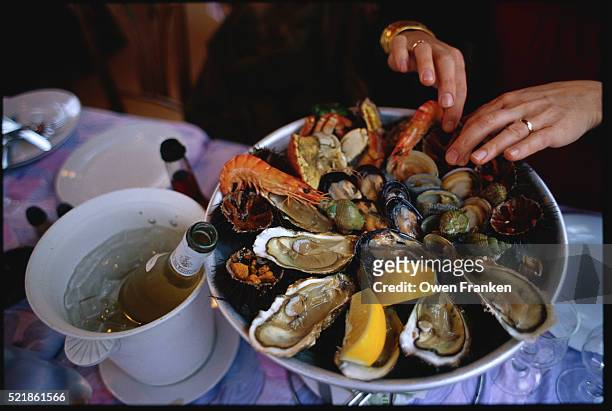 hands digging in seafood platter - seafood platter stock pictures, royalty-free photos & images