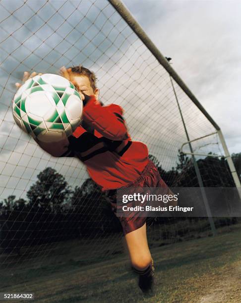 boy jumping after ball in goal - bad goalkeeper stock pictures, royalty-free photos & images