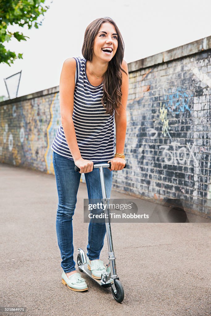 Young woman using scooter.