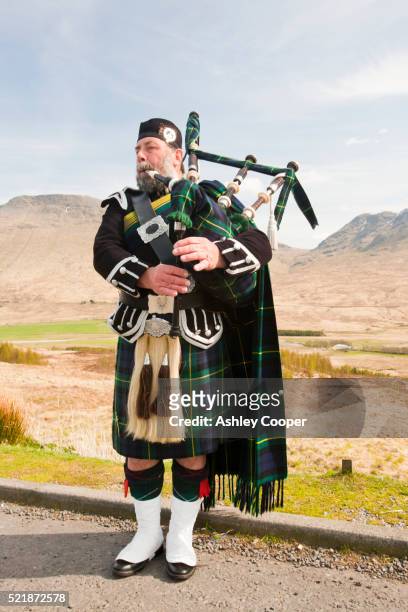 a scottish piper in traditional dress busking on rannoch moor in argyl, scotland, uk. - kilt stock pictures, royalty-free photos & images