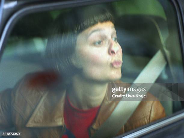 young woman in a car kissing the windscreen - auto küssen stock-fotos und bilder