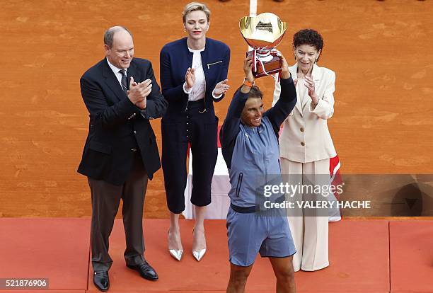 Spain's Rafael Nadal holds his trophy as Prince Albert II of Monaco, Princess Charlene of Monaco and Elisabeth-Anne de Massy applaud during the...