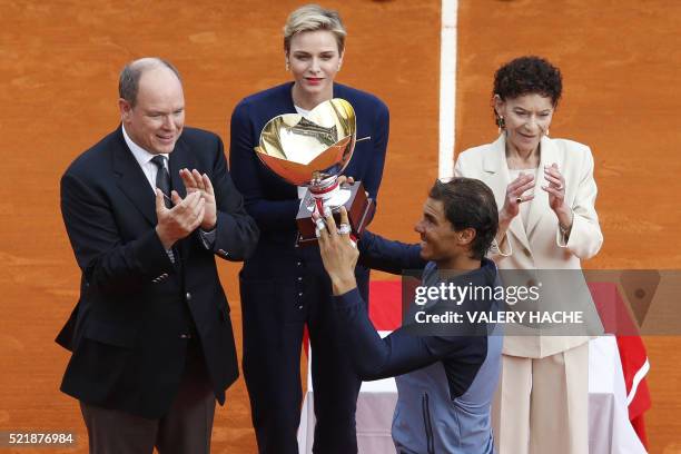 Spain's Rafael Nadal holds his trophy as Prince Albert II of Monaco, Princess Charlene of Monaco and Elisabeth-Anne de Massy applaud during the...