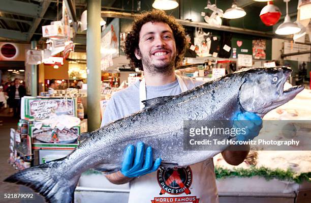 man with king salmon, pike place market, seattle - pike place fish market stock pictures, royalty-free photos & images