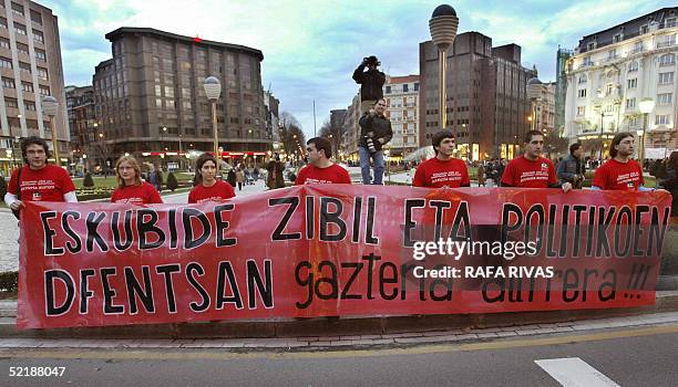 Seven members of the banned organization Haika hold a banner as thousands of people march against the February 20 European constitutional referendum...