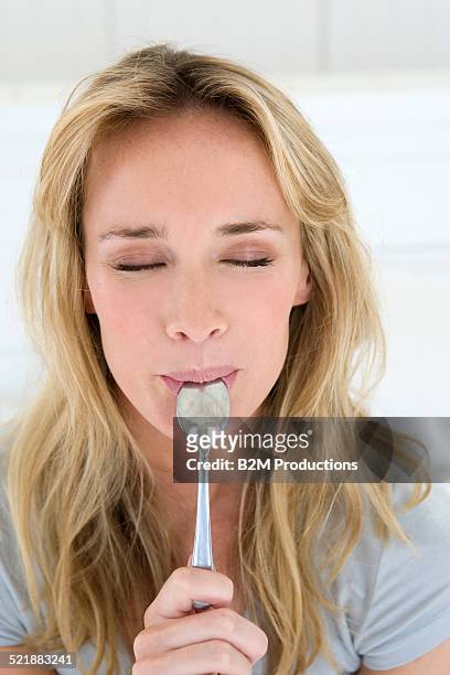 woman with spoon - im mund tragen stock-fotos und bilder