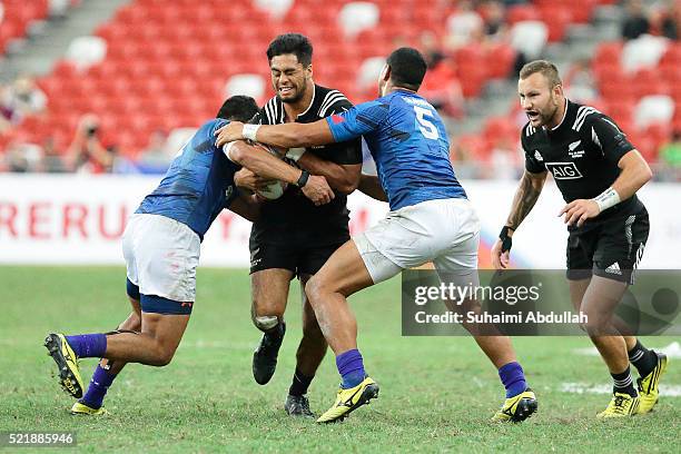 Regan Ware of New Zealand is tackled by Alex Samoa and Ed Fidow of Samoa during the 2016 Singapore Sevens Plate Final between New Zealand and Samoa...