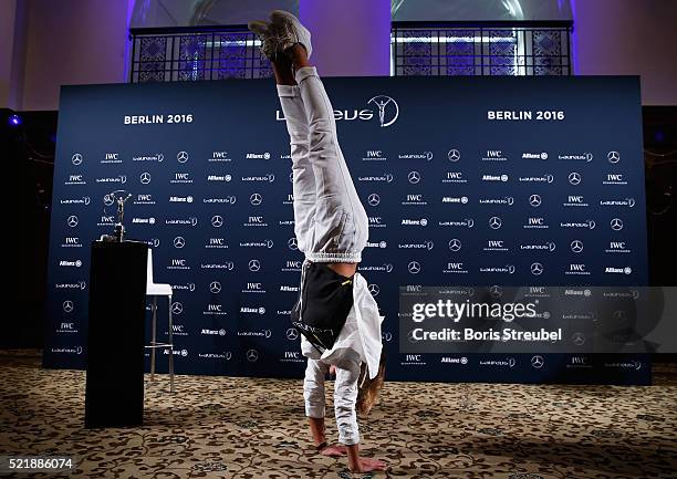 Laureus World Sports Academy member Nadia Comaneci performs a handstand at the press conference to celebrate 40 Years After The Perfect 10 on April...