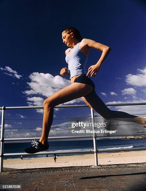 young woman running near beach - vintage running shorts stock pictures, royalty-free photos & images