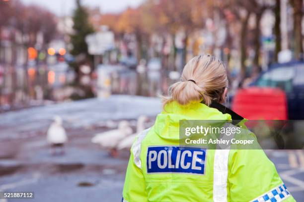 police officer keeping guard on main street - uk police woman stock pictures, royalty-free photos & images