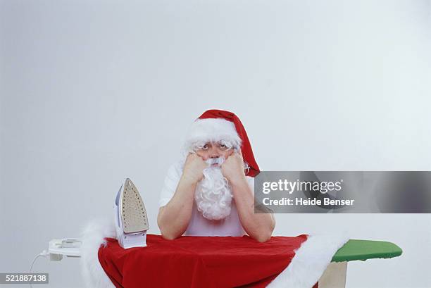 father christmas ironing - grumpy santa stock pictures, royalty-free photos & images