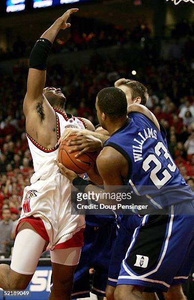 Travis Garrison of the Maryland Terrapins is fouled by Shelden Williams of the Duke Blue Devils during ACC Basketball action at the Comcast Center on...