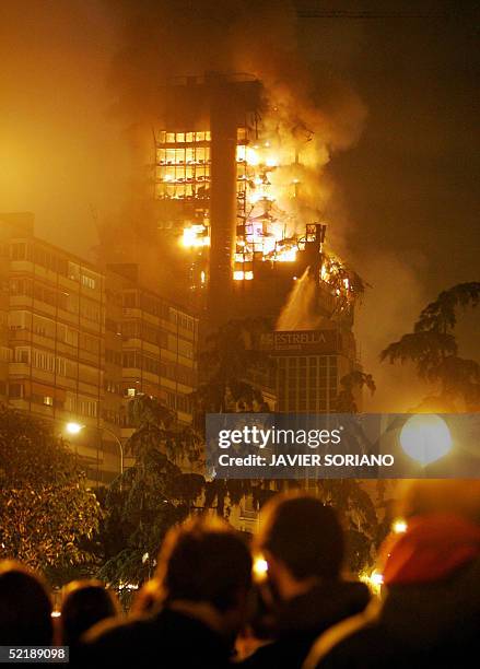 People watch as Windsor building burns in downtown Madrid, 13 February, 2005. Dozens of firefighters early Sunday battled a large blaze which broke...
