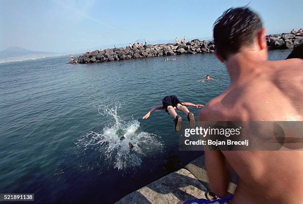 youths diving in naples - groyne stock pictures, royalty-free photos & images