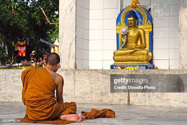 monk worshiping statue of gautam buddha, unesco world heritage mahabodhi temple, bodhgaya, bihar, india - world heritage mahabodhi stock pictures, royalty-free photos & images