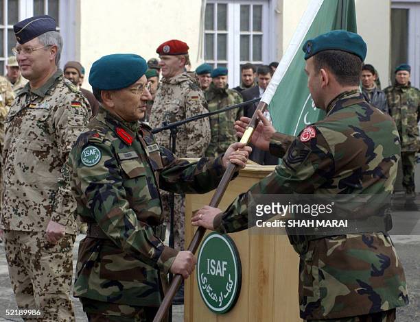 Incoming Commander Lieutenant General Ethem Erdagi hands the International Security Assistance Force flag to a Turkish soldier as German General...