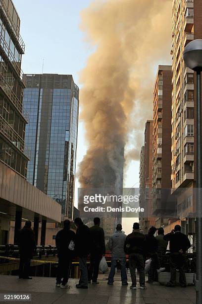 People watch the Windsor skyscraper smolder on February 13, 2005 in Madrid, Spain. There are no reported civilian casualties after the blaze broke...