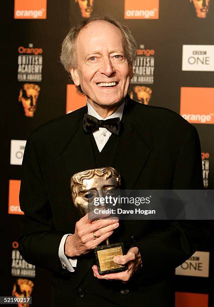 Composer John Barry poses with the 'BAFTA Fellowship' award at The Orange British Academy Film Awards 2005 at the Odeon Leicester Square on February...