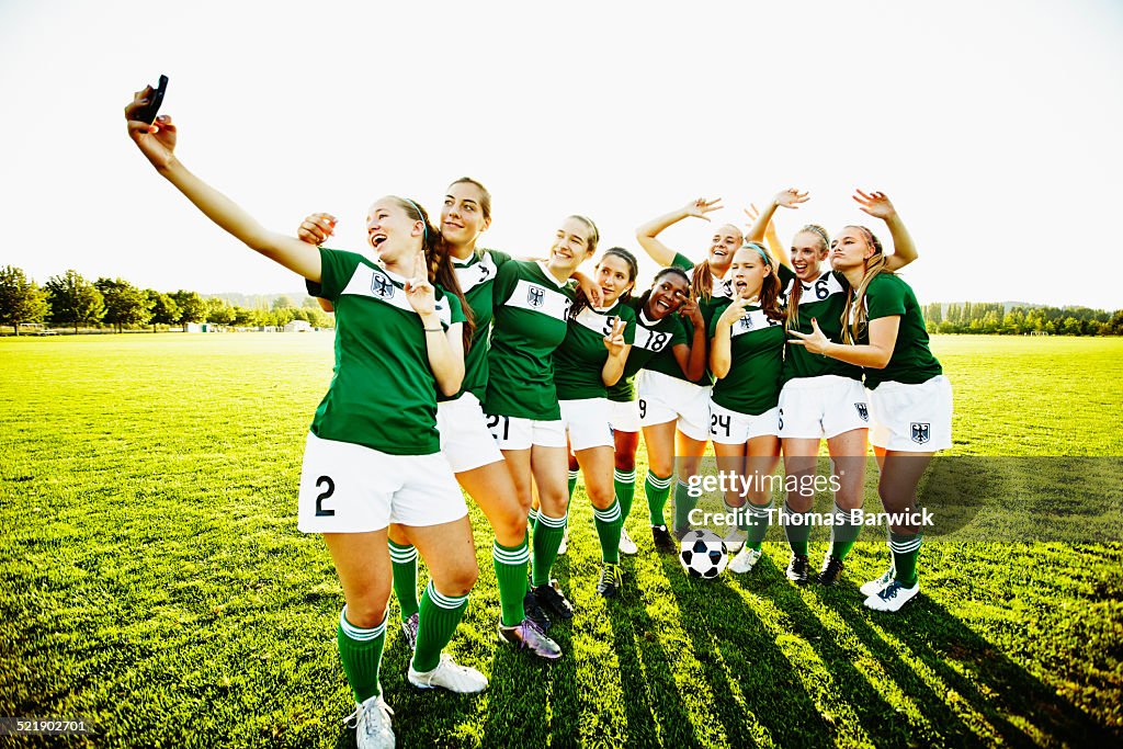 Female soccer teammates taking self portrait