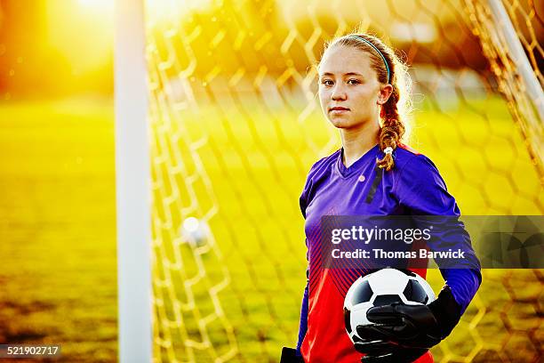 Female soccer goalie holding soccer ball