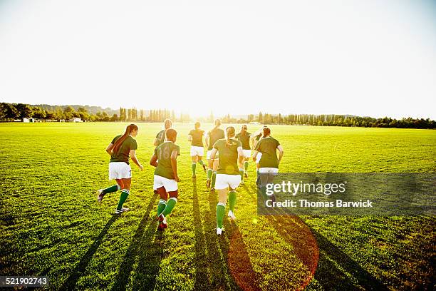 female soccer teammates warming up on grass field - playing field fotografías e imágenes de stock