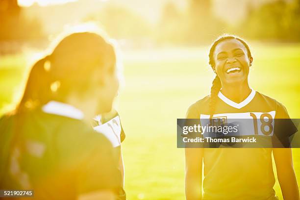 female soccer player laughing with teammates - jamaican girl stock pictures, royalty-free photos & images