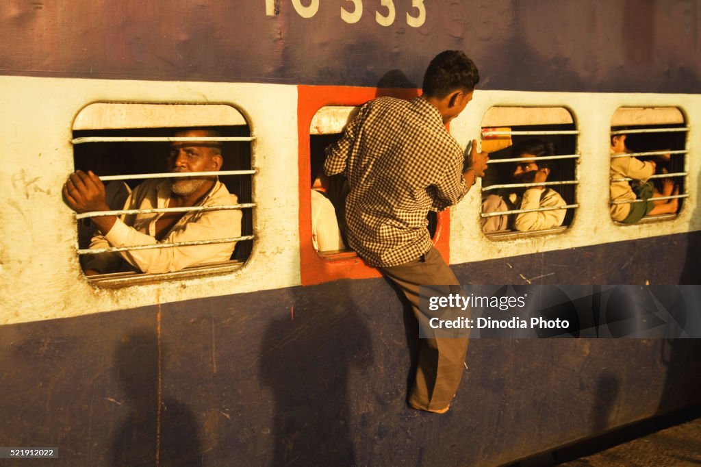 Man coming out emergency window from train at, surat railway station, Gujarat, India
