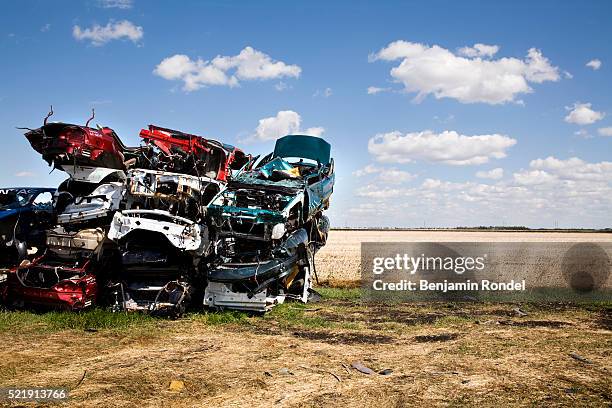 stack of junked cars beside a field - depósito de sucata - fotografias e filmes do acervo