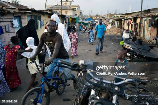 Daily life in a street in Zongo area on April 18, 2015 in Accra, Ghana. Many young unemployed men here are involved in Romance scams, credit card...