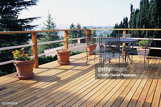 metal table and chairs on deck - terrace stockfoto's en -beelden