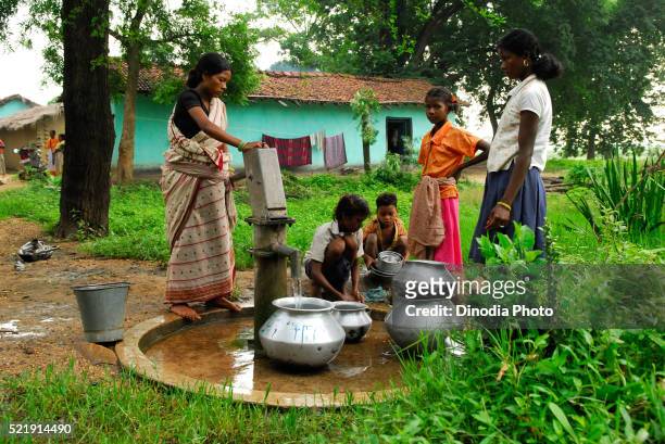 ho tribes women filling pots with water by handpump, chakradharpur, jharkhand, india - chakradharpur stock pictures, royalty-free photos & images