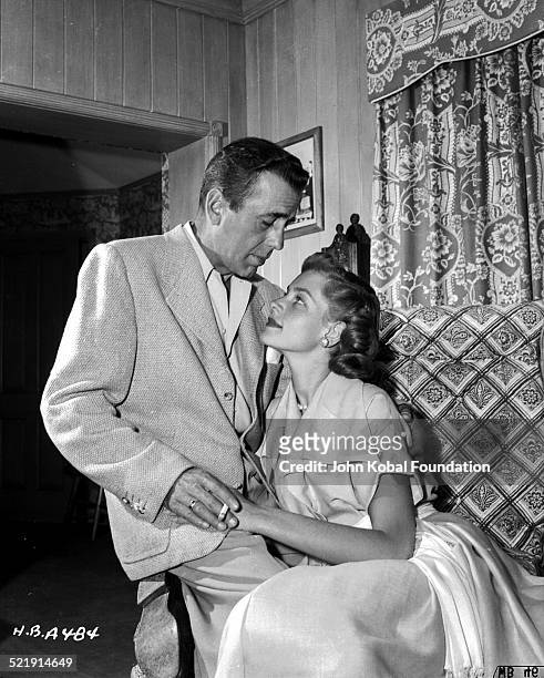 Posed portrait of actors and spouses Humphrey Bogart and Lauren Bacall in their home, for Warner Bros Studios, 1945.