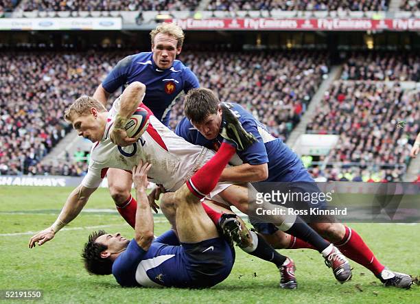Josh Lewsey of England is brought down by Christophe Dominici and Sylvain Marconnet of France during the RBS Six Nations International between...