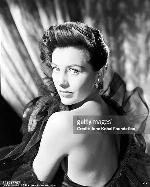 Headshot of actress Cyd Charisse with her bare back facing the camera, for MGM Studios, August 14th 1952.