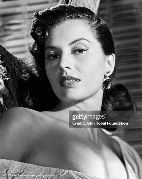 Headshot of actress Cyd Charisse wearing an off the shoulder blouse, for MGM Studios, August 14th 1952.