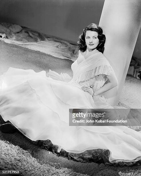 Portrait of actress Cyd Charisse sitting with the skirt of her dress laid out around her, for MGM Studios, April 4th 1946.