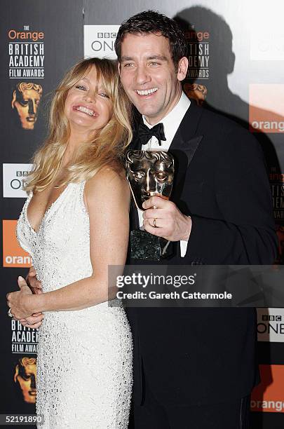 Actors Clive Owen and Goldie Hawn pose in the Awards Room with his award for Best Actor in a Supporting Role in for his role in "Closer" at The...