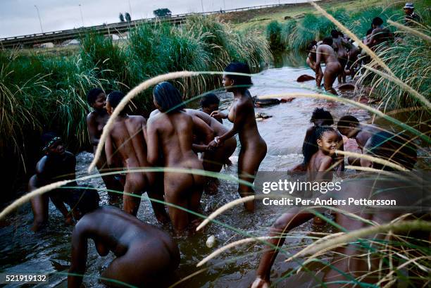 Zulu maidens wash themselves in a river in Soweto, Johannesburg, South Africa. About fifty girls celebrated their virginity by marching trough the...