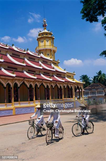 bicyclists outside the cao dai holy see - cycling vietnam stock-fotos und bilder