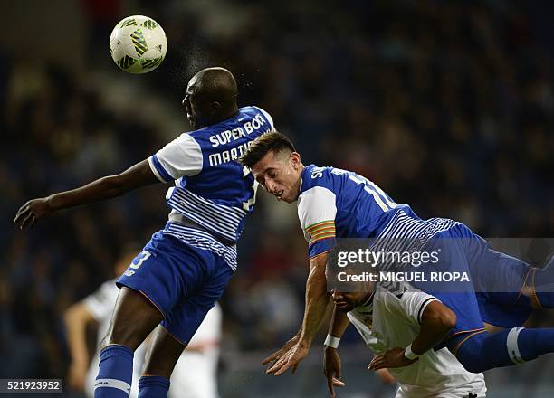 Porto's Dutch defender Bruno Martins Indi heads the ball next to teammate Mexican midfielder Hector Herrera and Nacional's Brazilian midfielder...